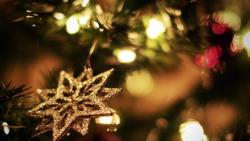 Glittering Gold Star Christmas Ornament on Festive Tree Desktop Wallpaper