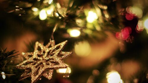 Glittering Gold Star Christmas Ornament on Festive Tree Desktop Wallpaper