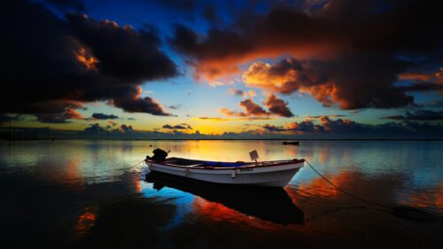 Serene Sunset Over Still Water with Fishing Boat 4K Desktop Wallpaper