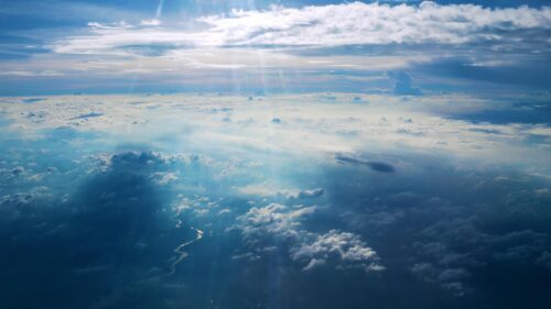 Sunlight Piercing Through Clouds Over Winding River Aerial View 4K Wallpaper
