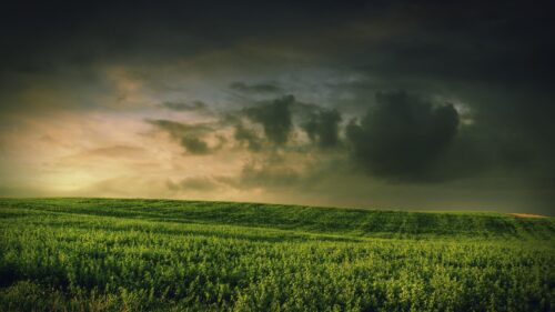 Dramatic Storm Clouds Over Rolling Green Fields 4K Desktop Wallpaper