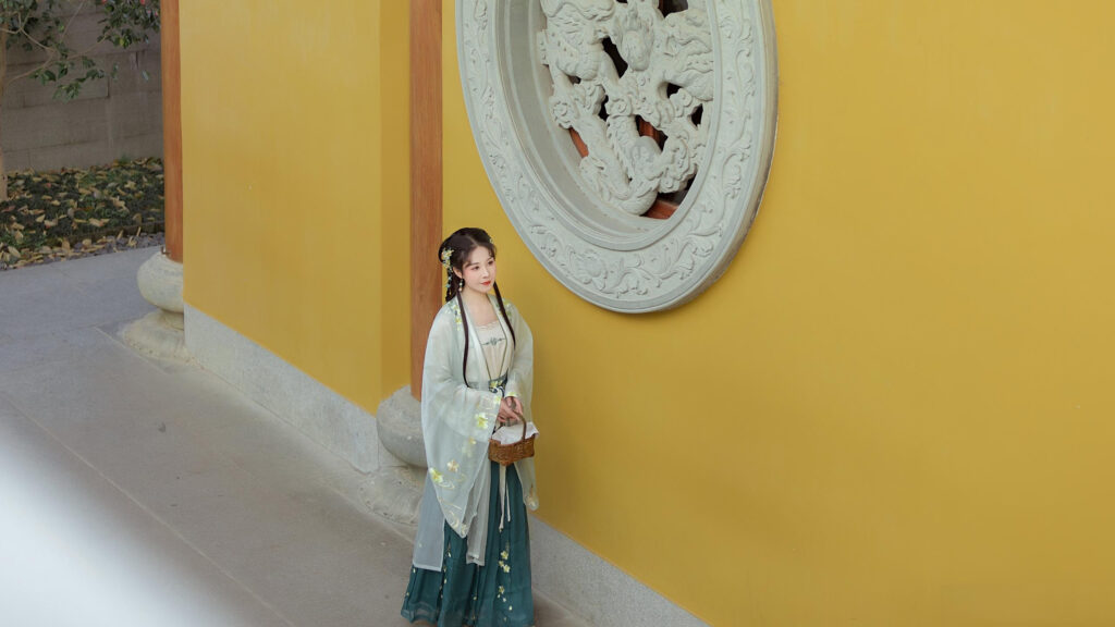 Elegant Woman in Traditional Hanfu Standing by Chinese Temple Wall 4K Wallpaper