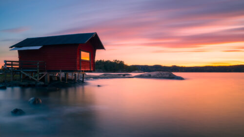 Stunning Red Boathouse at Sunset Over Calm Lake 4K Desktop Wallpaper