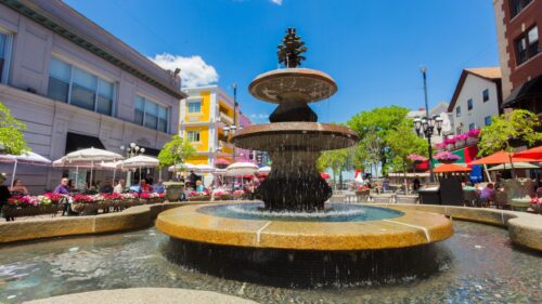 Stunning Italian Piazza Fountain with Outdoor Dining and Clear Blue Sky Desktop Wallpaper