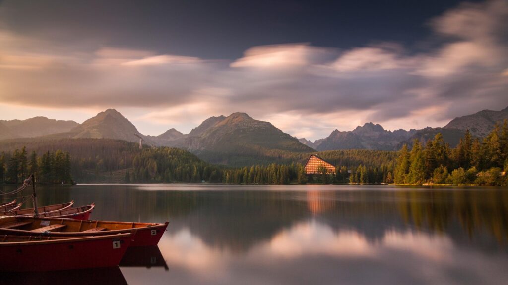 Stunning Strbske Pleso Lake with Wooden Boats and Mountain Sunset 4K Wallpaper