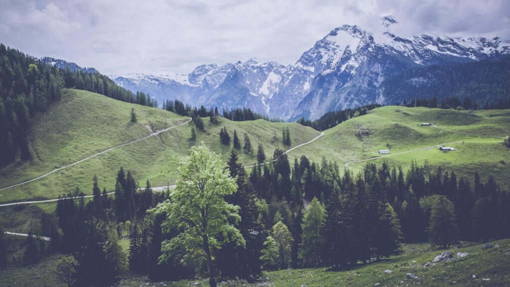 Breathtaking Alpine Mountain Valley Landscape with Rolling Green Hills Desktop Wallpaper