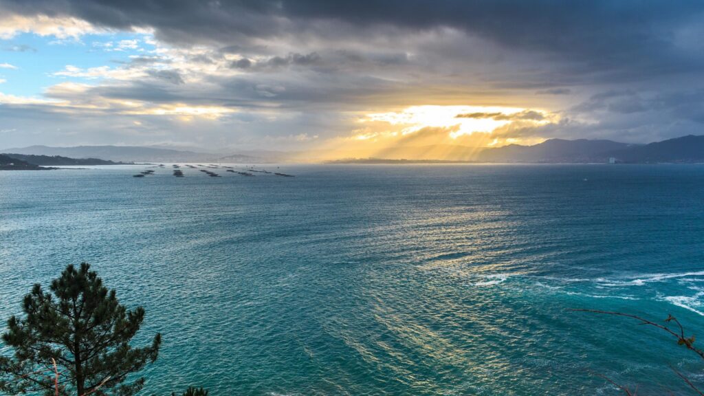 Stunning Seascape with Golden Sunbeams Breaking Through Stormy Clouds 4K Desktop Wallpaper