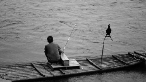 Solitary Fisherman on a Traditional Bamboo Raft with Cormorant Desktop Wallpaper