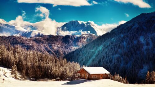Snow Covered Wooden Cabin in the Majestic Swiss Alps Desktop Wallpaper