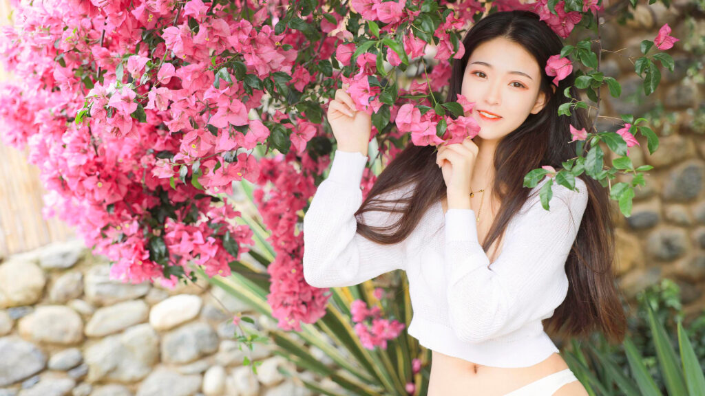Beautiful Young Woman Posing with Vibrant Pink Bougainvillea Flowers 4K Wallpaper