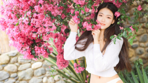 Beautiful Young Woman Posing with Vibrant Pink Bougainvillea Flowers 4K Wallpaper