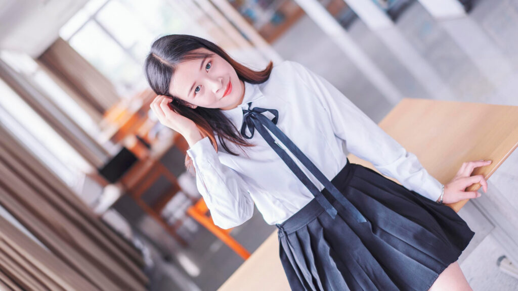 Beautiful Young Woman in School Uniform Sitting on a Desk 4K Desktop Wallpaper