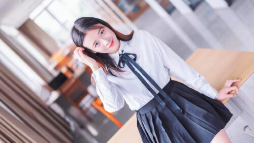 Beautiful Young Woman in School Uniform Sitting on a Desk 4K Desktop Wallpaper