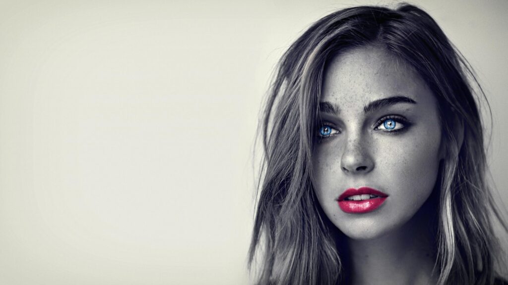 Stunning Portrait of a Woman with Piercing Blue Eyes and Vibrant Red Lips 4K Desktop Wallpaper
