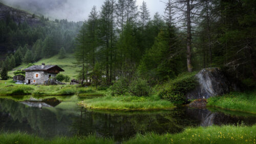 Rustic Stone Cabin by a Misty Alpine Pond 4K Wallpaper