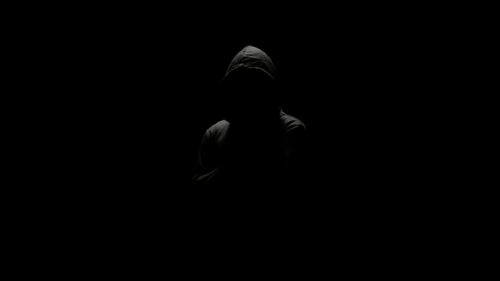 Mysterious Cloaked Figure in Dark Silhouette 4K Desktop Wallpaper