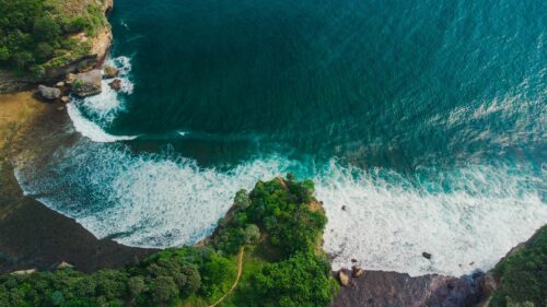 Stunning Aerial View of Tropical Coastal Cliffs and Azure Ocean Waves 4K Desktop Wallpaper