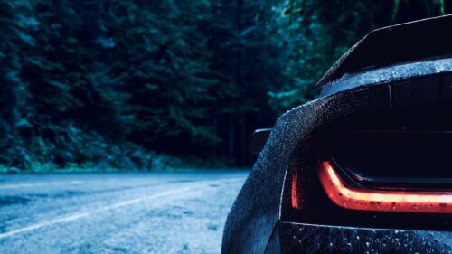 Stunning Sports Car Taillight in Moody Rainy Forest at Night 4K Wallpaper
