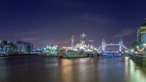 HMS Belfast Moored on the River Thames with Tower Bridge at Night 4K Wallpaper