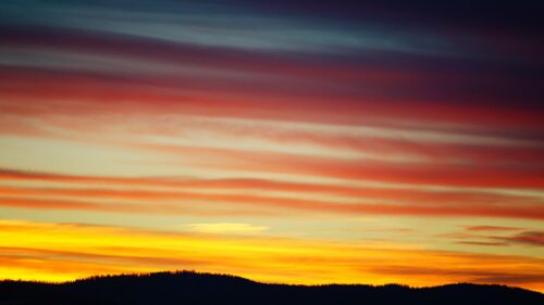 Stunning Golden Hour Sunset Over Silhouetted Forest Mountains 4K Wallpaper