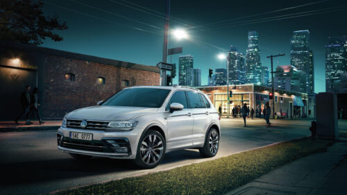 Volkswagen Tiguan R-Line SUV Driving Through a Modern City at Night 4K Wallpaper