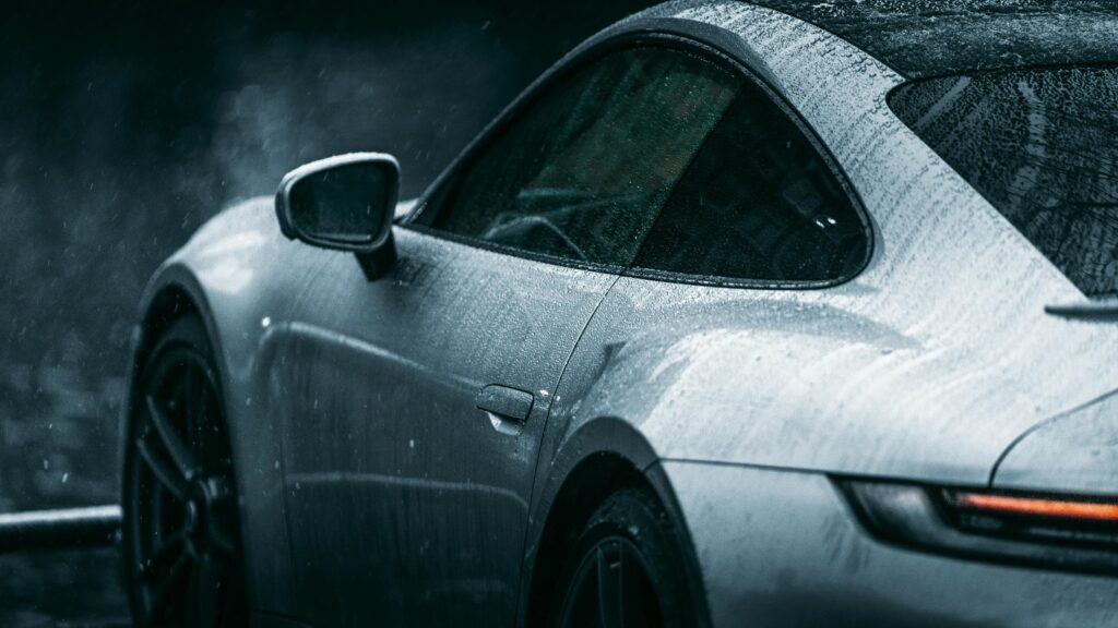 Sleek Silver Porsche Sports Car in Rain 4K Desktop Wallpaper