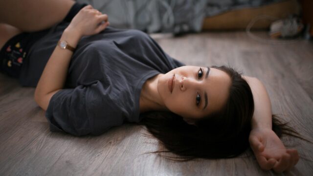 Beautiful Young Woman Resting on Wooden Floor 4K Desktop Wallpaper