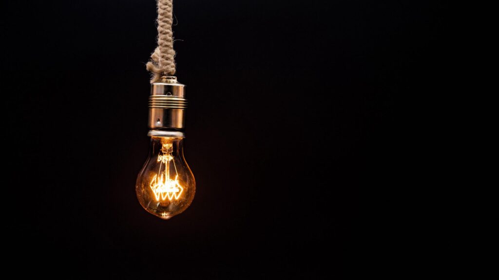 Minimalist Glowing Edison Light Bulb Hanging from Rope 4K Desktop Wallpaper
