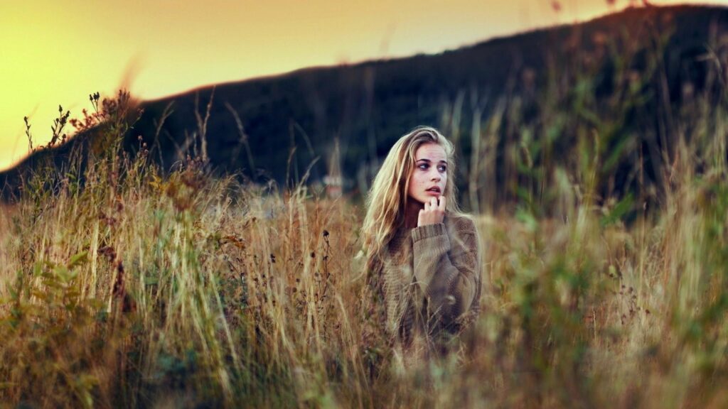 Stunning Blonde Woman in Golden Autumn Grass Field 4K Wallpaper