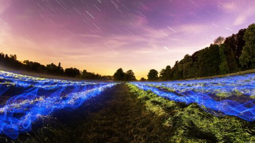 Surreal Night Landscape with Star Trails and Glowing Blue Light Fields PC Wallpaper