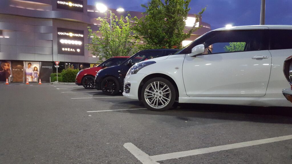 Trio of Modern Hatchback Cars Parked in a Mall Lot at Twilight Desktop Wallpaper