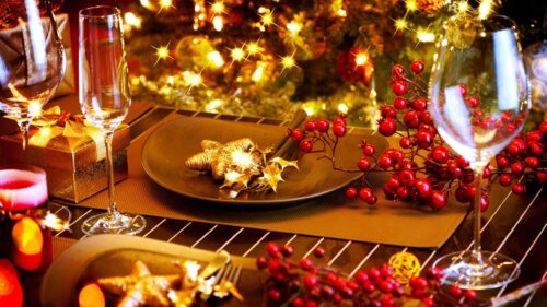 Elegant Christmas Dinner Table Setting with Golden Stars and Holly Berries 4K Wallpaper