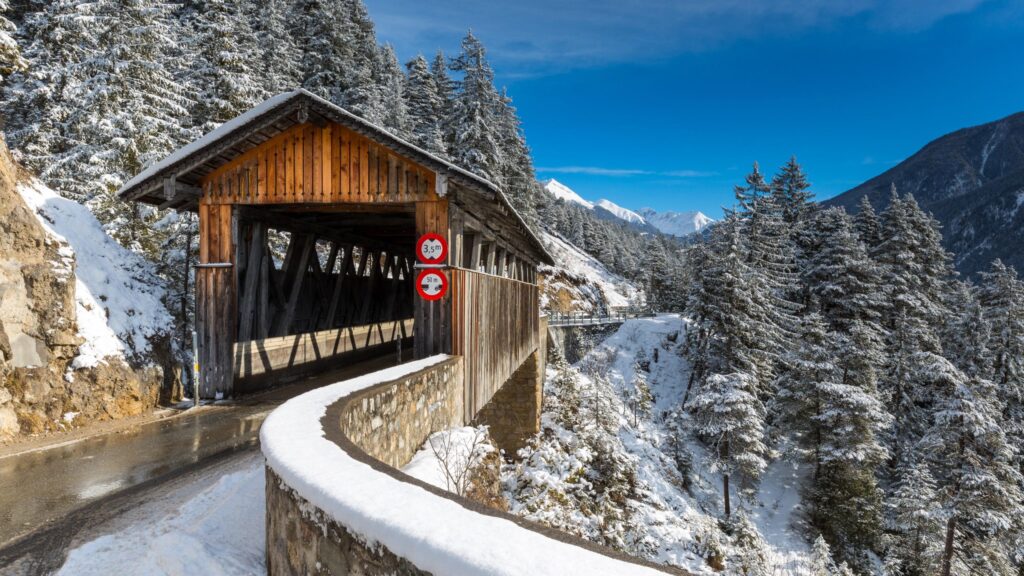 Snowy Covered Wooden Bridge in Alpine Winter Landscape 4K Wallpaper