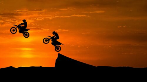 Motocross Riders Jumping at Golden Sunset 4K Desktop Wallpaper