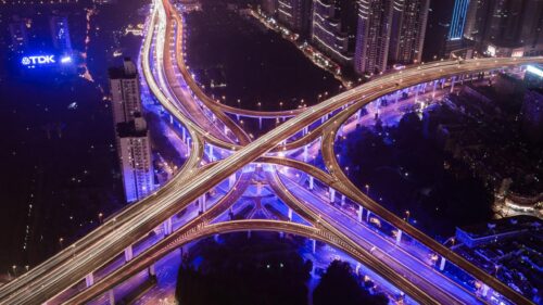 Stunning Aerial Night View of Urban Highway Interchange and City Lights 4K Wallpaper