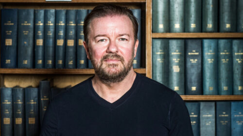 Ricky Gervais Portrait against Library Background Desktop Wallpaper