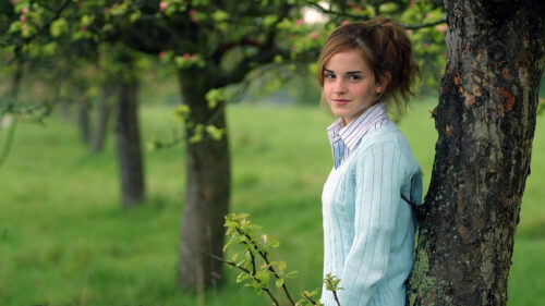 Emma Watson Leaning Against a Tree in a Field Desktop Wallpaper