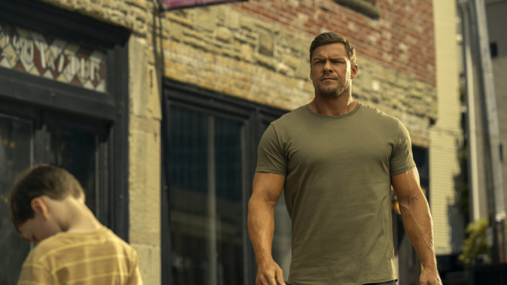 Jack Reacher Walking Past Child in City Scene 4K Wallpaper