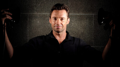 Portrait of Hugh Jackman against a textured wall Desktop Wallpaper