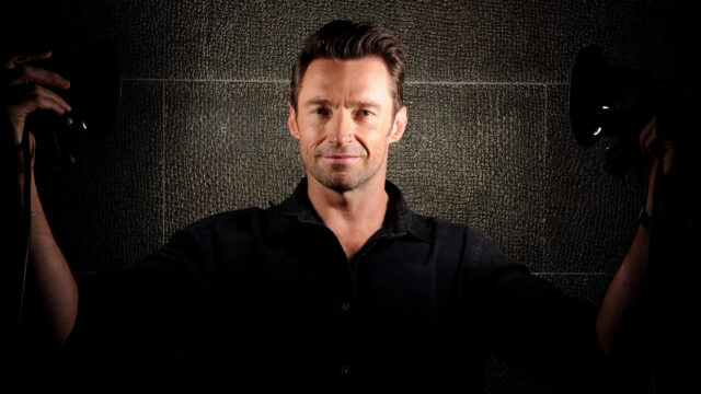 Portrait of Hugh Jackman against a textured wall Desktop Wallpaper