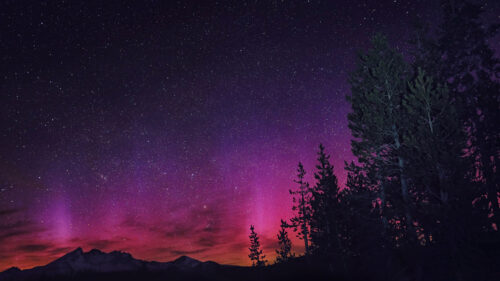 Vibrant Pink Aurora Borealis over Mountain Peaks Desktop Wallpaper