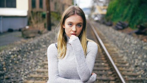 Young Woman in Gray Turtleneck Standing on Train Tracks Desktop Wallpaper