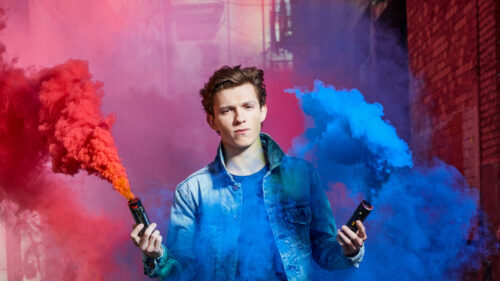 Young Man Holding Colorful Smoke Grenades Desktop Wallpaper