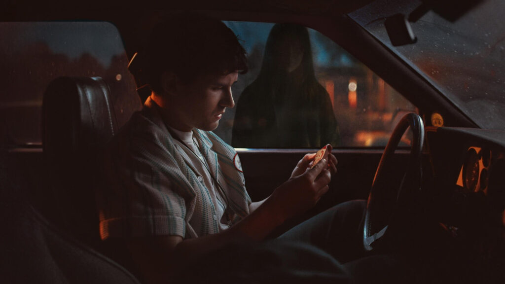 Young Man Sitting in Car Holding a Card 4K Wallpaper