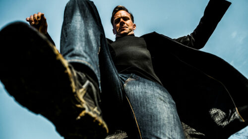 Man in Overcoat Looking Down Low Angle Desktop Wallpaper