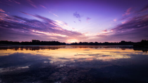 Breathtaking Purple Sunset Reflection over Calm Lake 4K Wallpaper