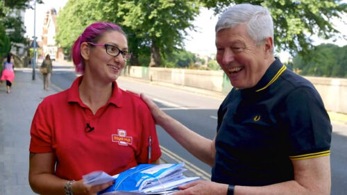 Friendly Royal Mail Postal Worker Meeting a Senior Citizen Desktop Wallpaper
