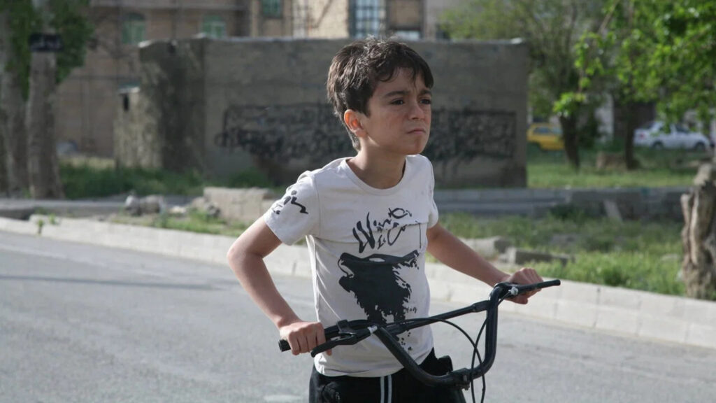 A Young Boy Riding a Bicycle Outdoors Desktop Wallpaper