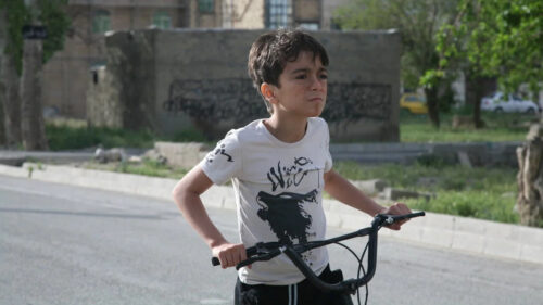 A Young Boy Riding a Bicycle Outdoors Desktop Wallpaper