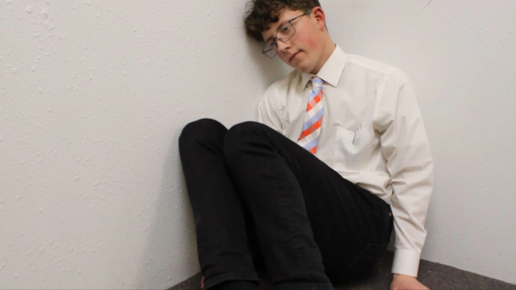Young Man Sitting in Corner Desktop Wallpaper